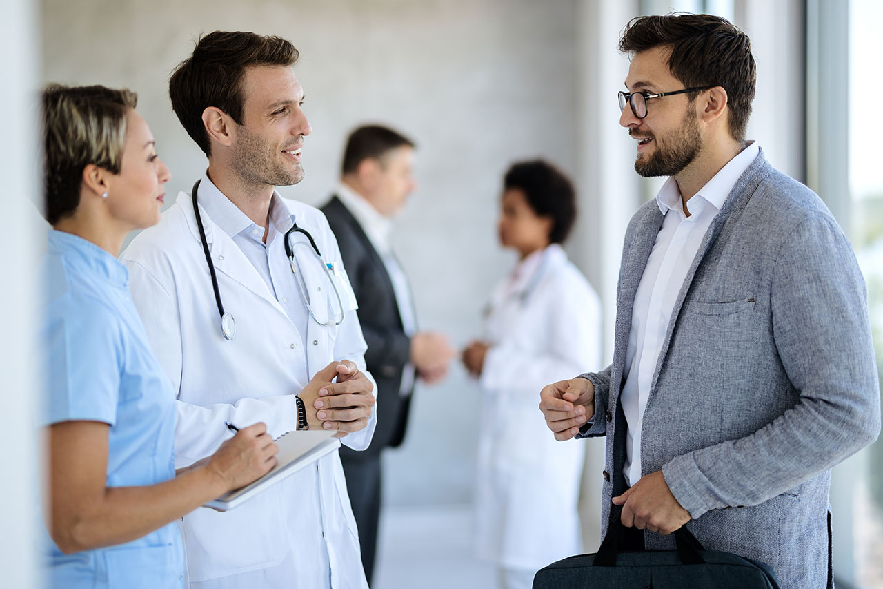 Businessman and doctor talking in a hallway at medical clinic.